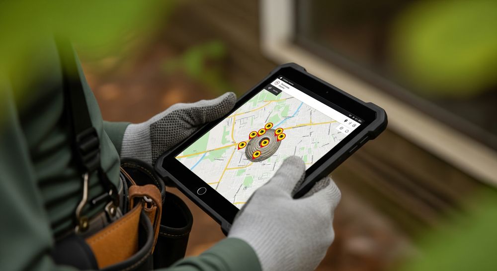 technicien consultant une carte des nids de frelons sur une tablette